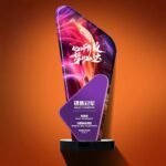 The trophy can be customized with text and is made of artificial crystal and mirrored glass